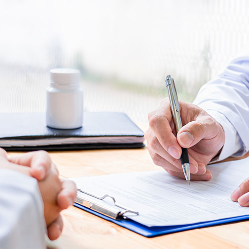 close up showing the hands of doctor writing notes on paper and patient
