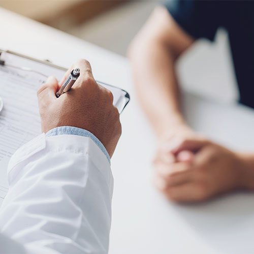 doctor holding test results and consulting patient at desk medical office
