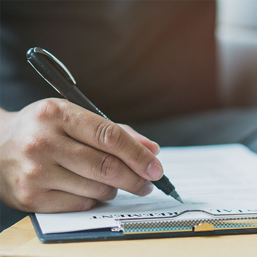 Close up Hands of person filling application form or writing personal information in contract.